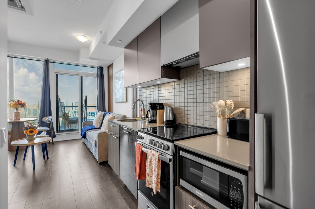 Open kitchen with breakfast-bar seating and a balcony beyond